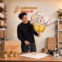 Jesse houdt de Cupcake Helium XL Ballon vast in de warme inpakruimte van Ballonnenshop.nl.