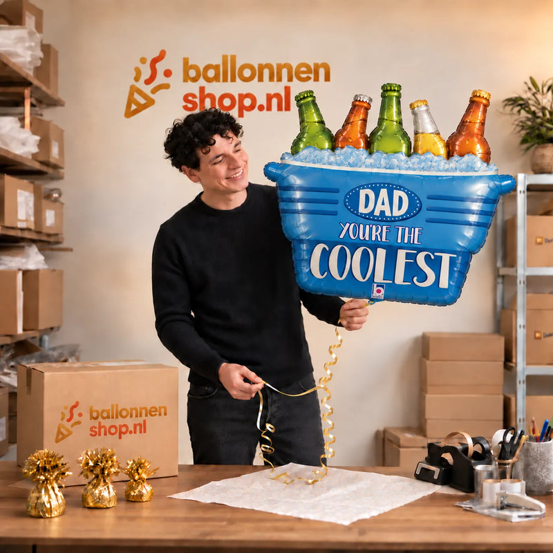 Jesse houdt de Dad You're The Coolest XL Ballon vast in de warme inpakruimte van Ballonnenshop.nl.