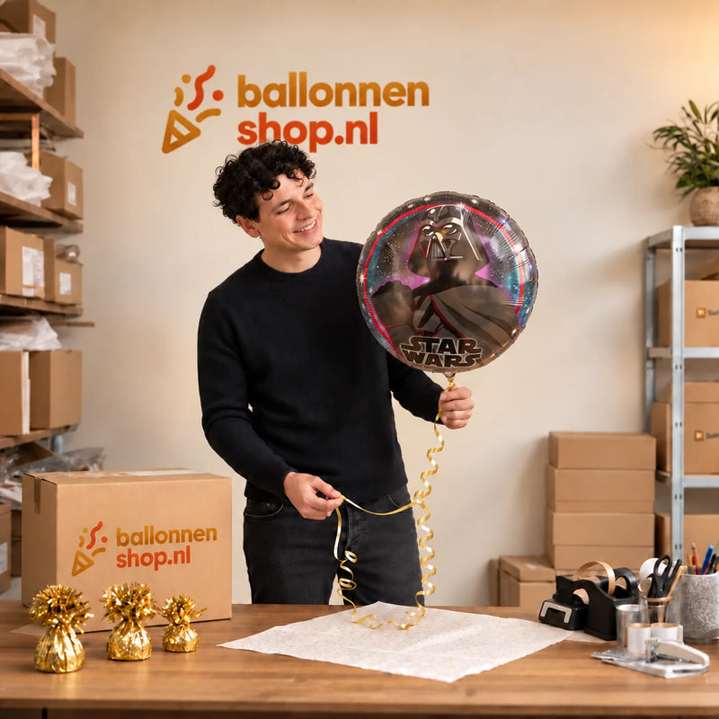 Jesse houdt de Darth Vader Helium Ballon vast in de warme inpakruimte van Ballonnenshop.nl.