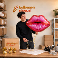 Jesse houdt de Dikke Zoen Ballon vast in de warme inpakruimte van Ballonnenshop.nl.