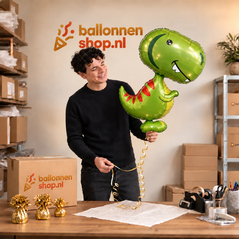 Jesse houdt de Dino Helium XL Ballon vast in de warme inpakruimte van Ballonnenshop.nl.