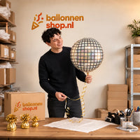 Jesse houdt de Discobal Helium Ballon vast in de warme inpakruimte van Ballonnenshop.nl.