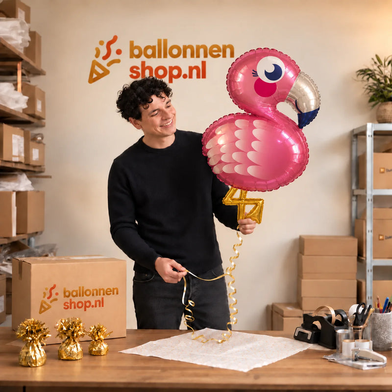 Jesse houdt de Flamingo Helium XL Ballon vast in de warme inpakruimte van Ballonnenshop.nl.