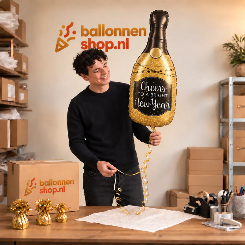 Jesse houdt de Glittering New Year XL Ballon vast in de warme inpakruimte van Ballonnenshop.nl.