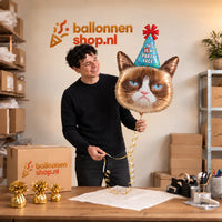 Jesse houdt de Grumpy Cat XL Helium Ballon vast in de warme inpakruimte van Ballonnenshop.nl.
