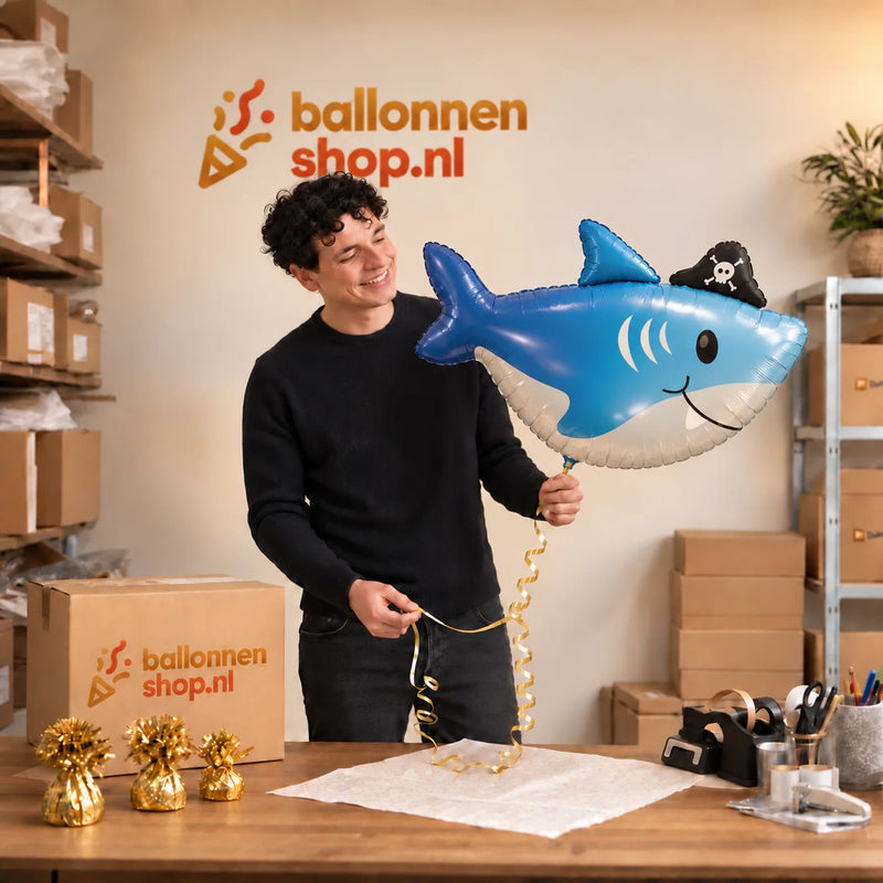 Jesse houdt de Haai Helium XL Ballon vast in de warme inpakruimte van Ballonnenshop.nl.