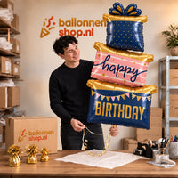 Jesse houdt de Happy Birthday Cadeaus Luxe Geschenktrio vast in de warme inpakruimte van Ballonnenshop.nl.