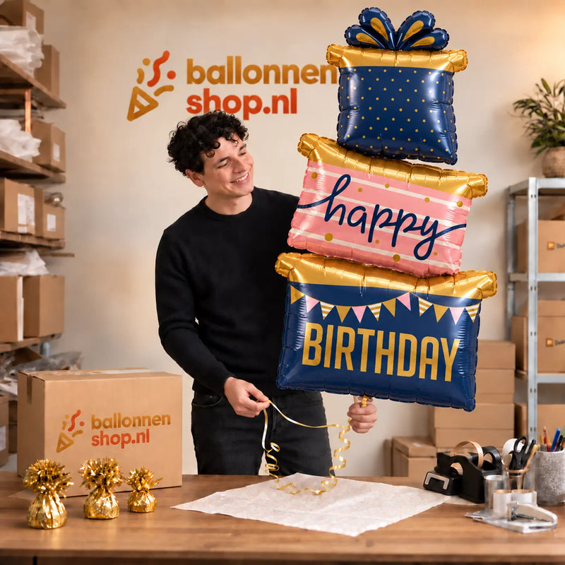 Jesse houdt de Happy Birthday Cadeaus Luxe Geschenktrio vast in de warme inpakruimte van Ballonnenshop.nl.