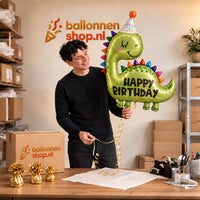 Jesse houdt de Happy Birthday Dino XL Ballon vast in de warme inpakruimte van Ballonnenshop.nl.