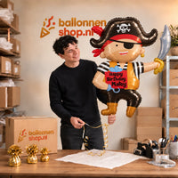 Jesse houdt de Happy Birthday Matey Piraat XL vast in de warme inpakruimte van Ballonnenshop.nl.