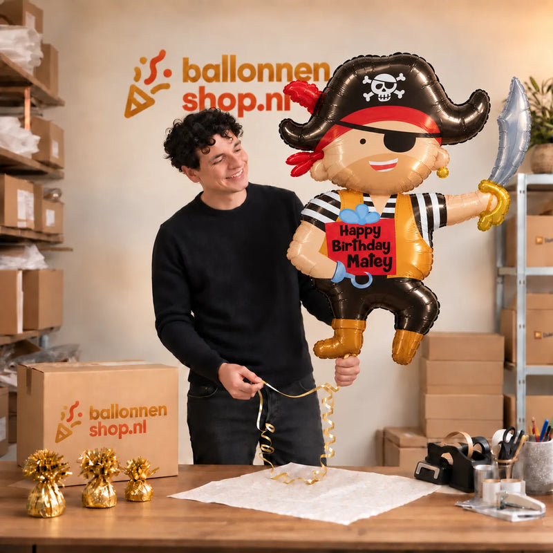 Jesse houdt de Happy Birthday Matey Piraat XL vast in de warme inpakruimte van Ballonnenshop.nl.