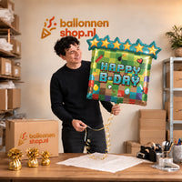 Jesse houdt de Happy Birthday Minecraft Ballon vast in de warme inpakruimte van Ballonnenshop.nl.