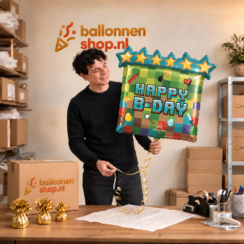 Jesse houdt de Happy Birthday Minecraft Ballon vast in de warme inpakruimte van Ballonnenshop.nl.