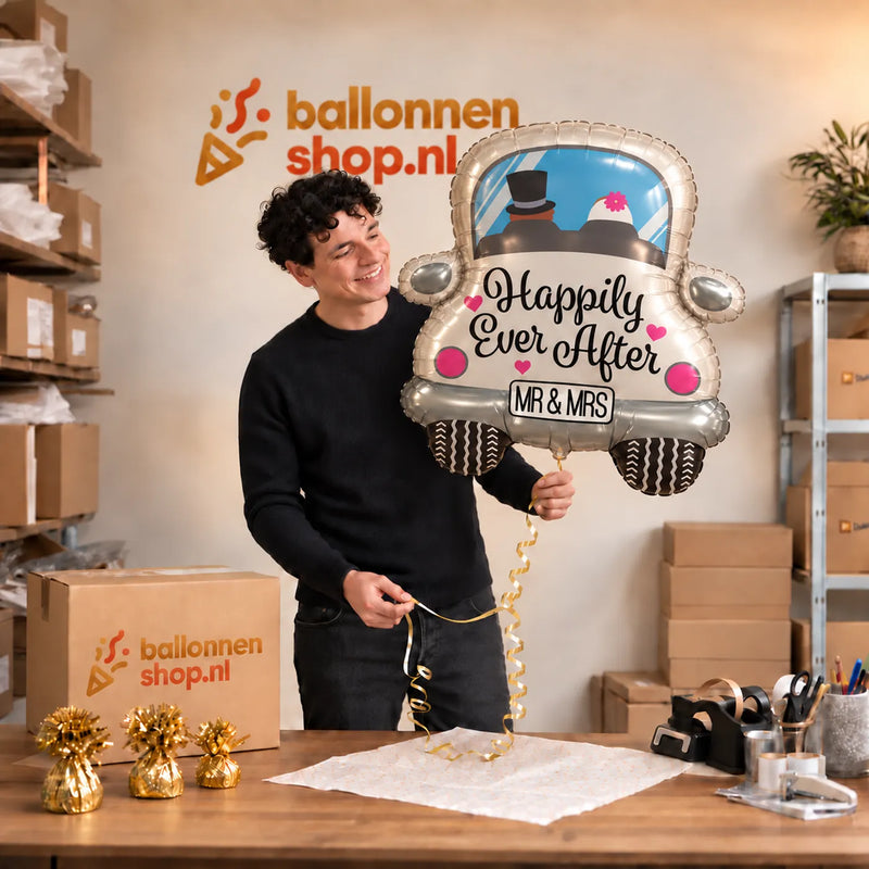 Jesse houdt de Happy Ever After Auto XL Ballon vast in de warme inpakruimte van Ballonnenshop.nl.