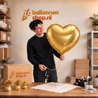 Jesse houdt de Grote Gouden Hartjes ballon vast in de warme inpakruimte van Ballonnenshop.nl.