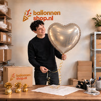 Jesse houdt de Hart Ballon Zilver – 61 cm vast in de warme inpakruimte van Ballonnenshop.nl.