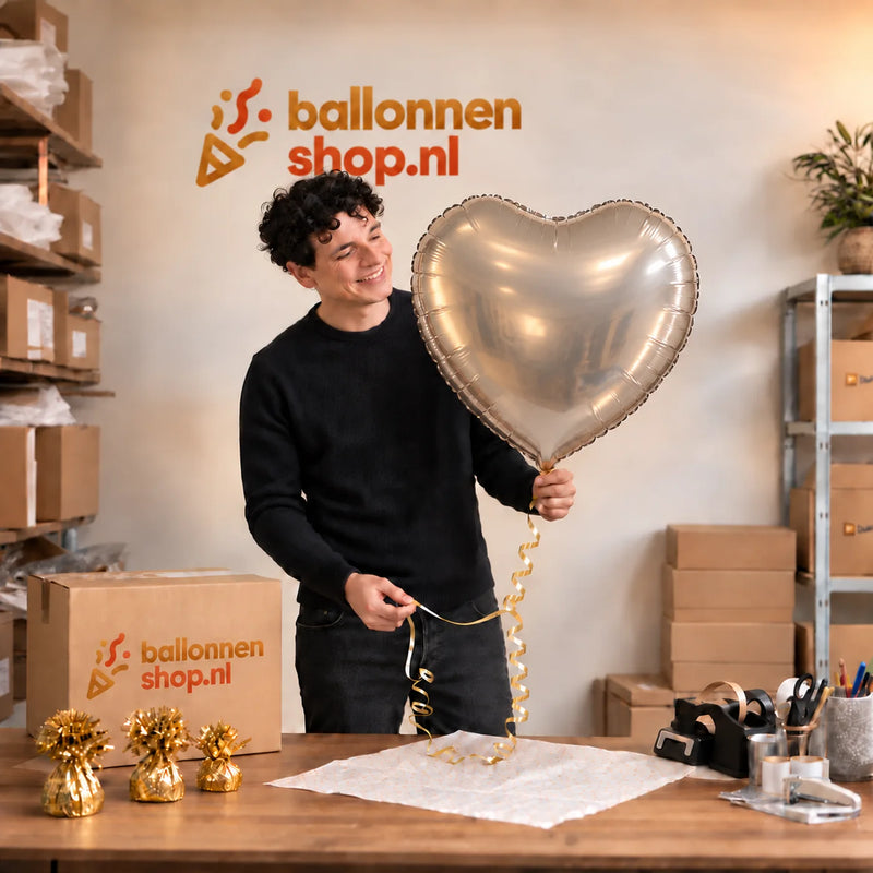 Jesse houdt de Hart Ballon Zilver – 61 cm vast in de warme inpakruimte van Ballonnenshop.nl.
