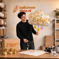 Jesse houdt de Hello Baby Wolk Met Sterren XL vast in de warme inpakruimte van Ballonnenshop.nl.