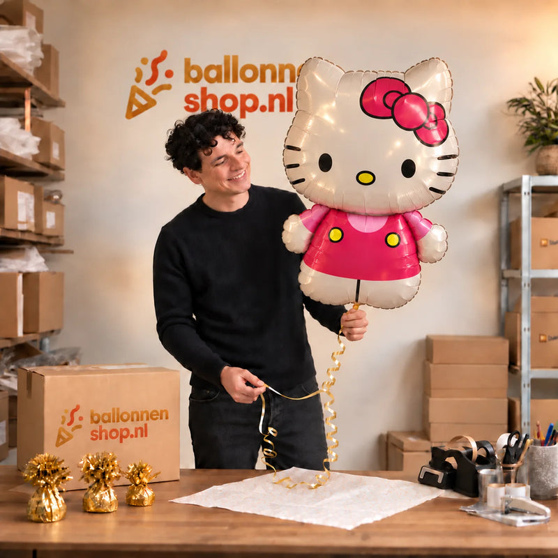 Jesse houdt de Hello Kitty Helium XL Ballon vast in de warme inpakruimte van Ballonnenshop.nl.