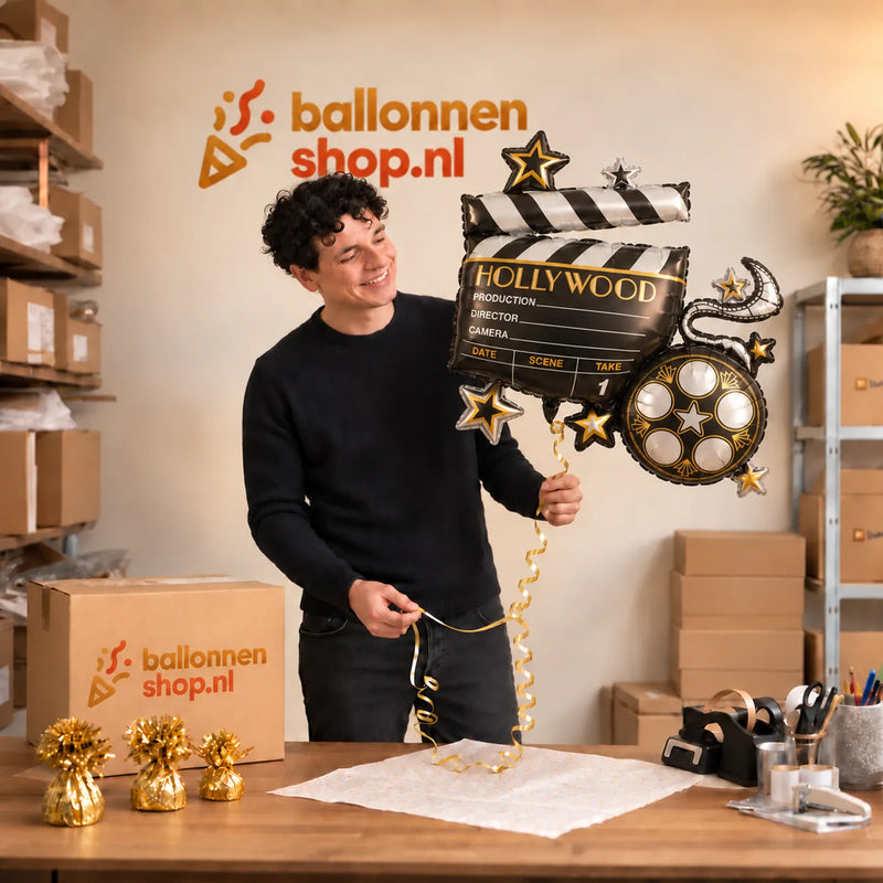 Jesse houdt de Hollywood Helium XL Ballon vast in de warme inpakruimte van Ballonnenshop.nl.