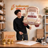 Jesse houdt de Just Married Auto XL Ballon vast in de warme inpakruimte van Ballonnenshop.nl.