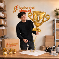 Jesse houdt de Kampioensbeker Helium Ballon vast in de warme inpakruimte van Ballonnenshop.nl.