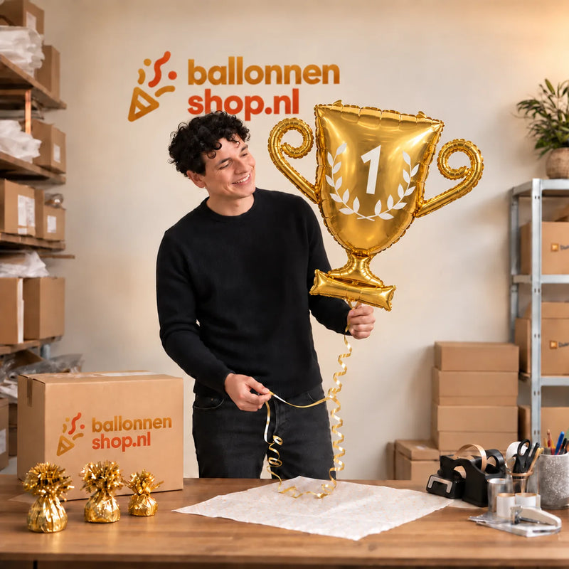 Jesse houdt de Kampioensbeker Helium Ballon vast in de warme inpakruimte van Ballonnenshop.nl.