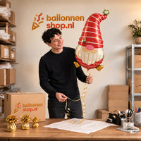 Jesse houdt de Kerstkabouter Helium Ballon vast in de warme inpakruimte van Ballonnenshop.nl.