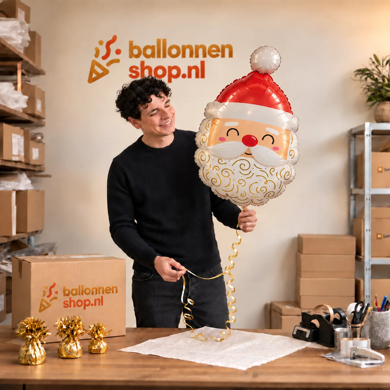 Jesse houdt de kerstmanballon van 62 cm vast in de warme inpakruimte van Ballonnenshop.nl.