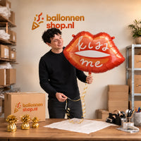 Jesse houdt de Kiss Me Helium XL Ballon vast in de warme inpakruimte van Ballonnenshop.nl.