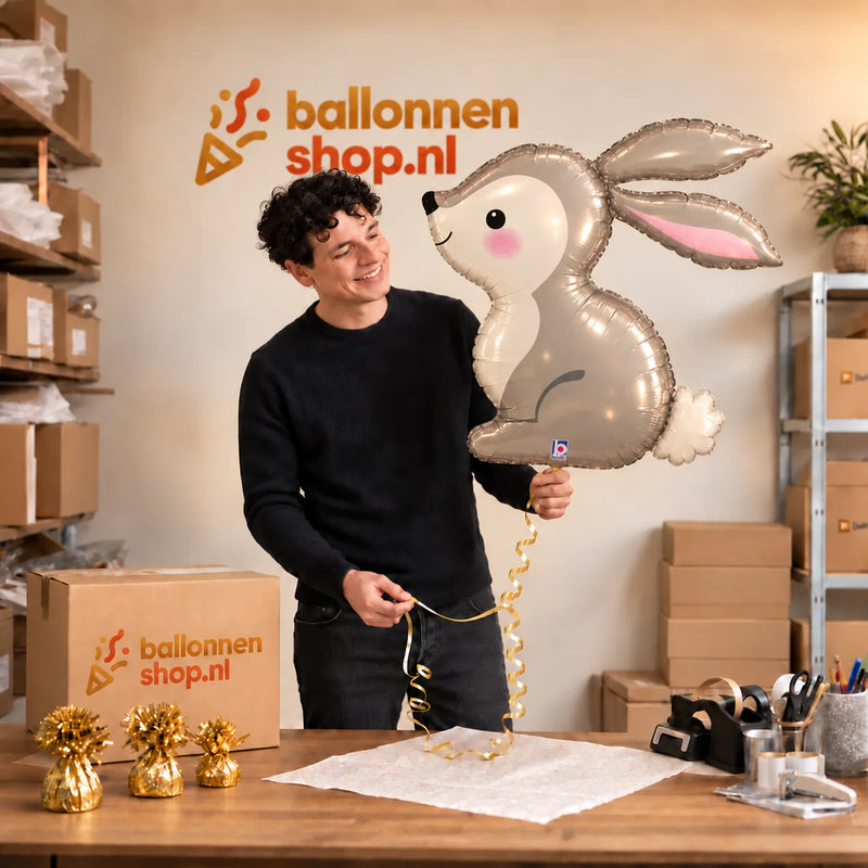 Jesse houdt de Konijn Helium XL Ballon vast in de warme inpakruimte van Ballonnenshop.nl.