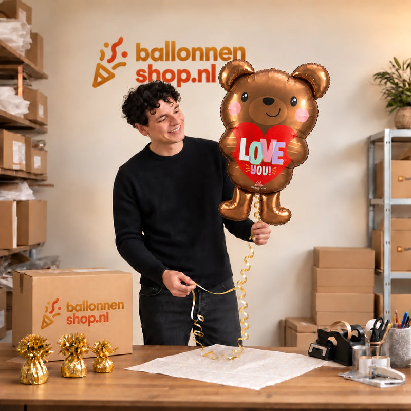 Jesse houdt de Love You! Beer Ballon vast in de warme inpakruimte van Ballonnenshop.nl.