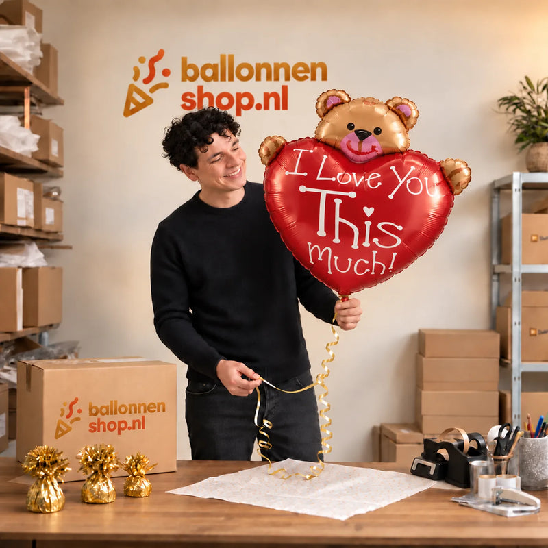 Jesse houdt de XL Love You This Much Beer – Toon Liefde met een Knipoog vast in de warme inpakruimte van Ballonnenshop.nl.