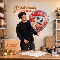 Jesse houdt de Marshall Paw Patrol XL Ballon vast in de warme inpakruimte van Ballonnenshop.nl.