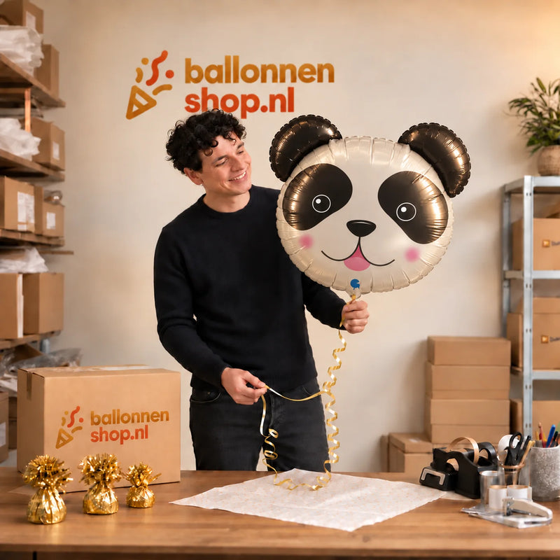 Jesse houdt de Panda Helium XL Ballon vast in de warme inpakruimte van Ballonnenshop.nl.