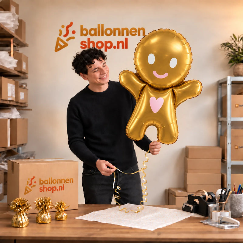 Jesse houdt de Peperkoekmannetje XL Ballon vast in de warme inpakruimte van Ballonnenshop.nl.