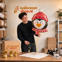 Jesse houdt de Pinguïn Helium Ballon vast in de warme inpakruimte van Ballonnenshop.nl.