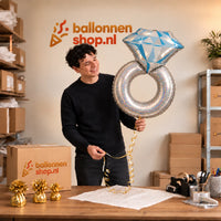 Jesse houdt de Platinum Zilveren Ring XL Ballon vast in de warme inpakruimte van Ballonnenshop.nl.