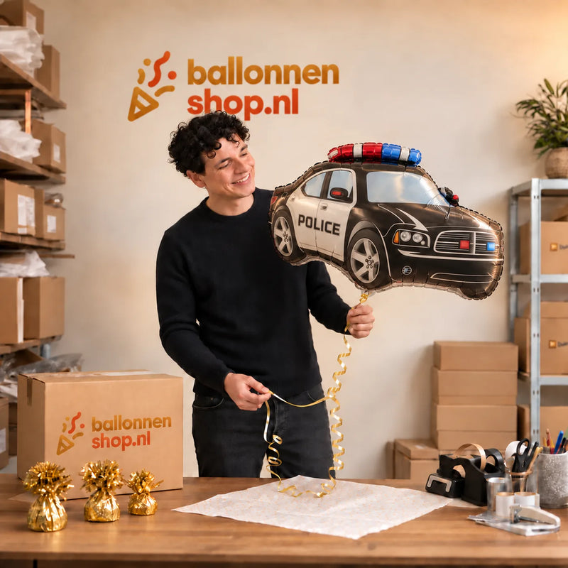 Jesse houdt de Politie Helium XL Ballon vast in de warme inpakruimte van Ballonnenshop.nl.