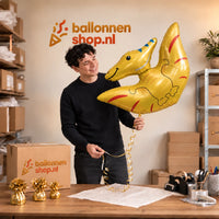 Jesse houdt de Pterodactyl Dino Helium XL Ballon vast in de warme inpakruimte van Ballonnenshop.nl.