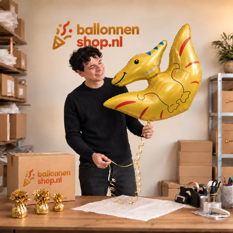 Jesse houdt de Pterodactyl Dino Helium XL Ballon vast in de warme inpakruimte van Ballonnenshop.nl.