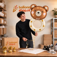 Jesse houdt de Rammelaar Beer Helium XL Ballon vast in de warme inpakruimte van Ballonnenshop.nl.