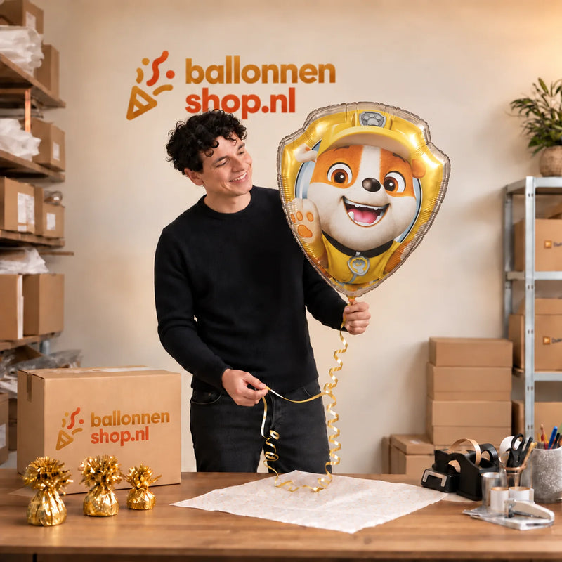 Jesse houdt de Rubble Paw Patrol XL Ballon vast in de warme inpakruimte van Ballonnenshop.nl.