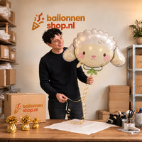 Jesse houdt de Schaap Helium Ballon vast in de warme inpakruimte van Ballonnenshop.nl.