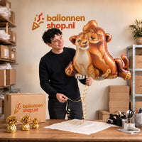 Jesse houdt de Simba & Nala Lion King XL Ballon vast in de warme inpakruimte van Ballonnenshop.nl.