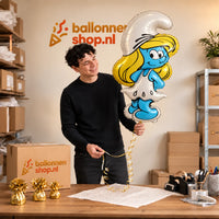 Jesse houdt de Smurfin Helium XL Ballon vast in de warme inpakruimte van Ballonnenshop.nl.