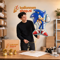 Jesse houdt de Sonic Helium XL Ballon vast in de warme inpakruimte van Ballonnenshop.nl.