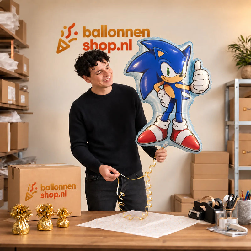 Jesse houdt de Sonic Helium XL Ballon vast in de warme inpakruimte van Ballonnenshop.nl.
