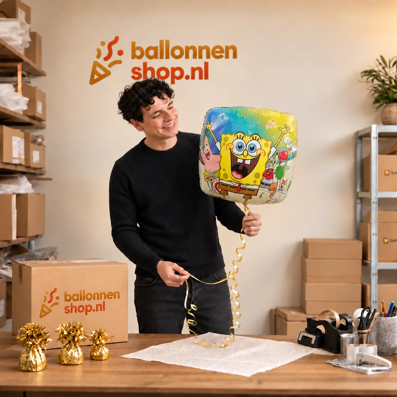 Jesse houdt de Spongebob Helium Ballon vast in de warme inpakruimte van Ballonnenshop.nl.