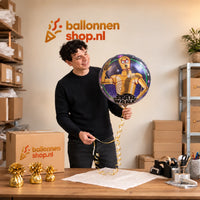 Jesse houdt de Star Wars C3PO Helium Ballon vast in de warme inpakruimte van Ballonnenshop.nl.
